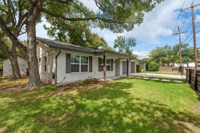 a view of a house with backyard and sitting area