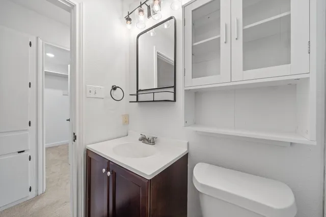 a bathroom with a toilet sink and mirror