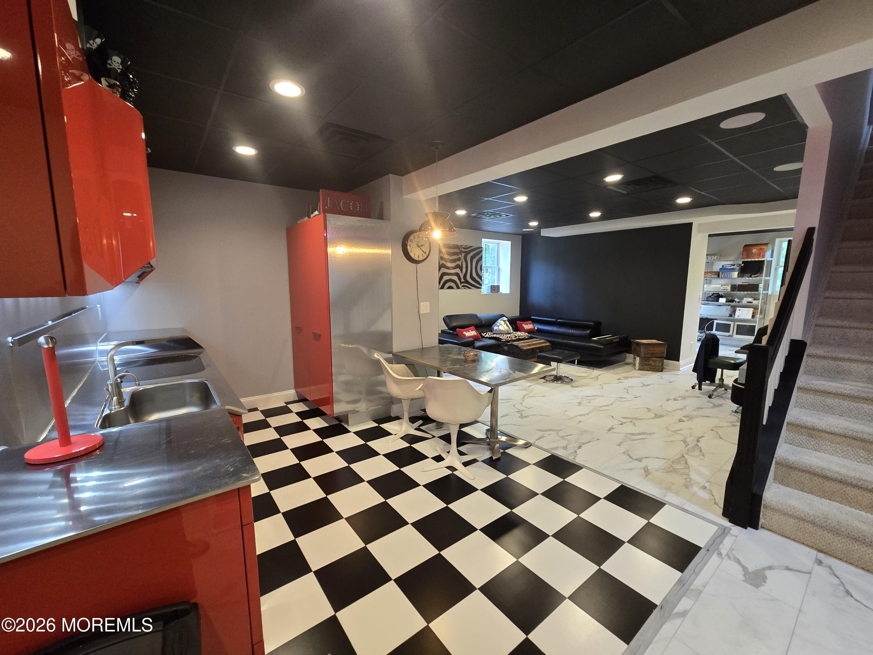 112 Beacon Hill Road Morganville, NJ 07751 - Photo 43 of 53 a room with a black white checkered floor with a gaming machine and appliances