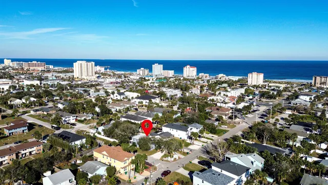 a view of a house with a small yard and palm trees