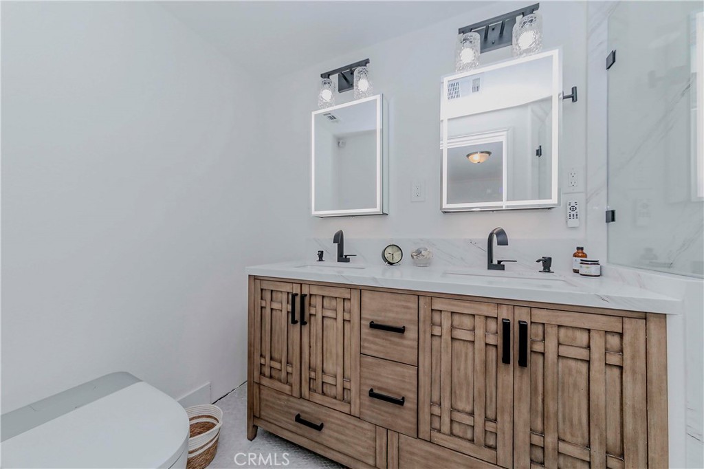10252 Lorraine Lane Cypress, CA 90630 - Photo 29 of 44 a bathroom with a sink a toilet and mirror