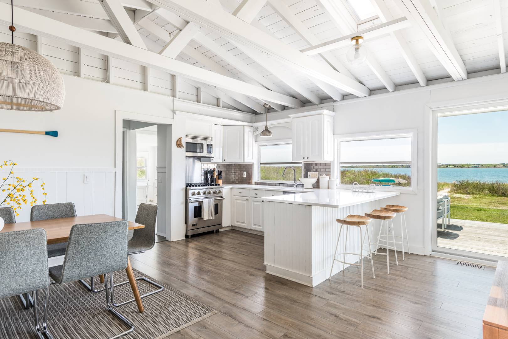 351 East Lake Drive Montauk, NY 11954 - Photo 4 of 30 a kitchen with stainless steel appliances kitchen island granite countertop a refrigerator a stove a dining table and chairs with wooden floor