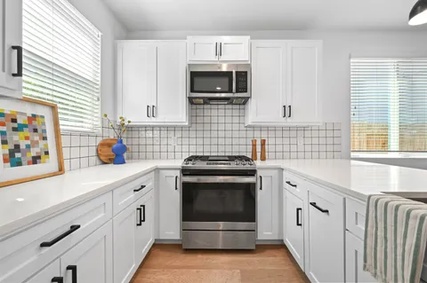 a kitchen with stainless steel appliances a stove microwave and cabinets