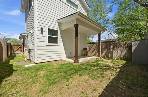 a view of backyard with potted plants and wooden fence