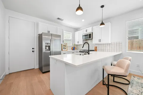 a open kitchen with stainless steel appliances granite countertop a stove and a sink