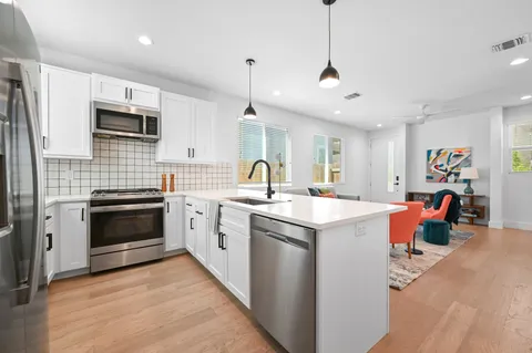a kitchen with cabinets a window and stainless steel appliances