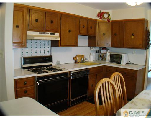 104 Idlewild Road Edison, NJ 08817 - Photo 4 of 13 a kitchen with stainless steel appliances granite countertop a stove a sink and a microwave