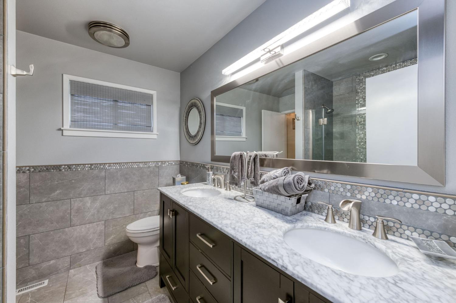 6811 North Backer Avenue Fresno, CA 93710 - Photo 15 of 26 a bathroom with a granite countertop toilet sink and mirror