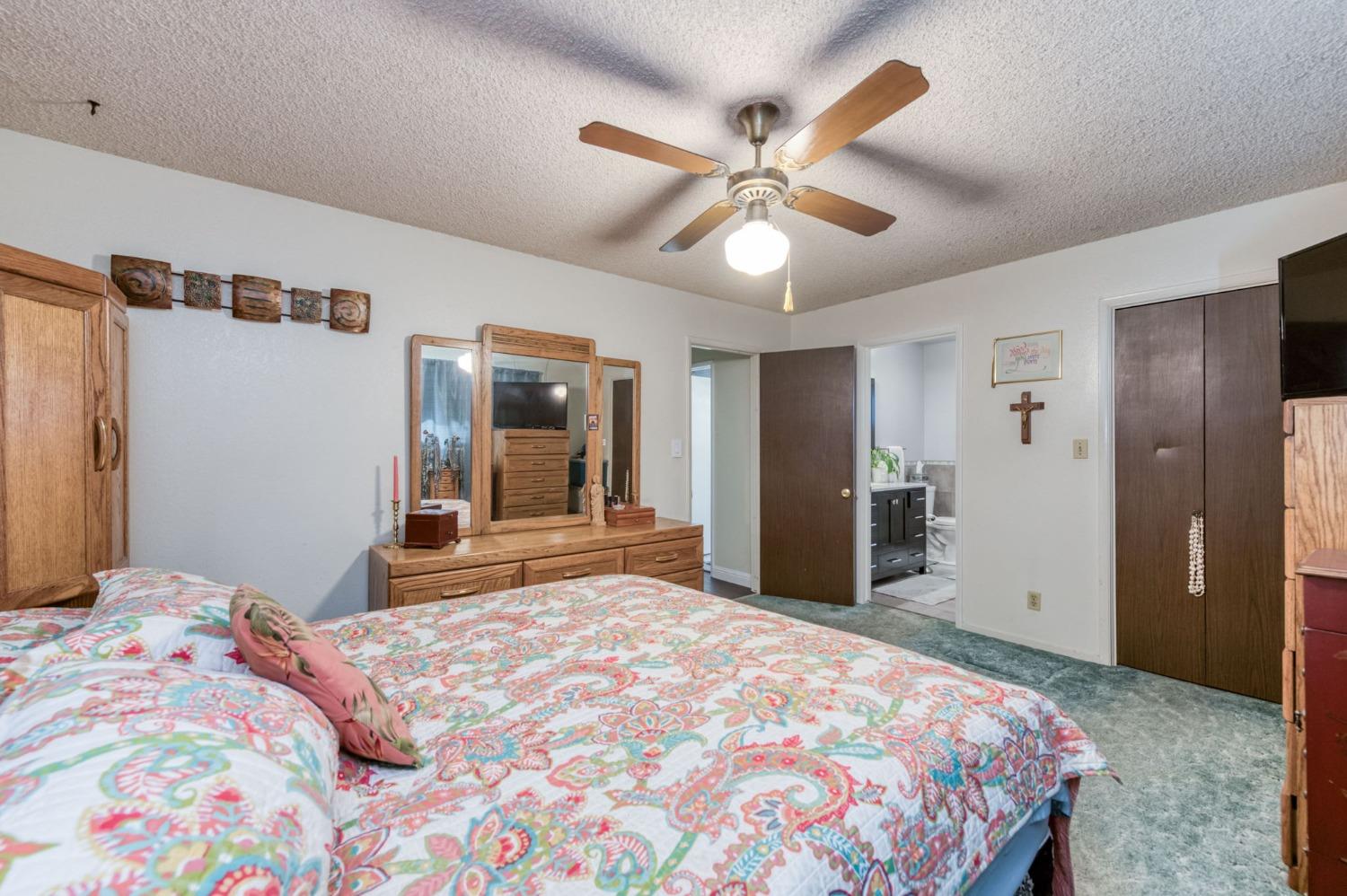 6811 North Backer Avenue Fresno, CA 93710 - Photo 19 of 26 a bedroom with a large bed and a chandelier