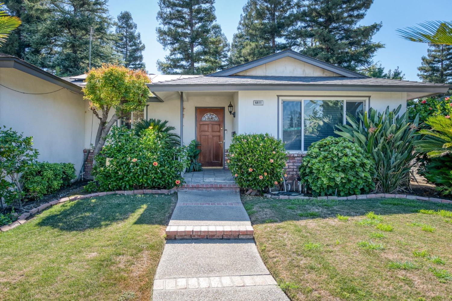 6811 North Backer Avenue Fresno, CA 93710 - Photo 3 of 26 a front view of a house with garden