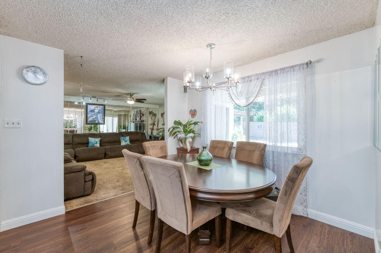 6811 North Backer Avenue Fresno, CA 93710 - Photo 4 of 26 a view of a dining room with furniture wooden floor and chandelier