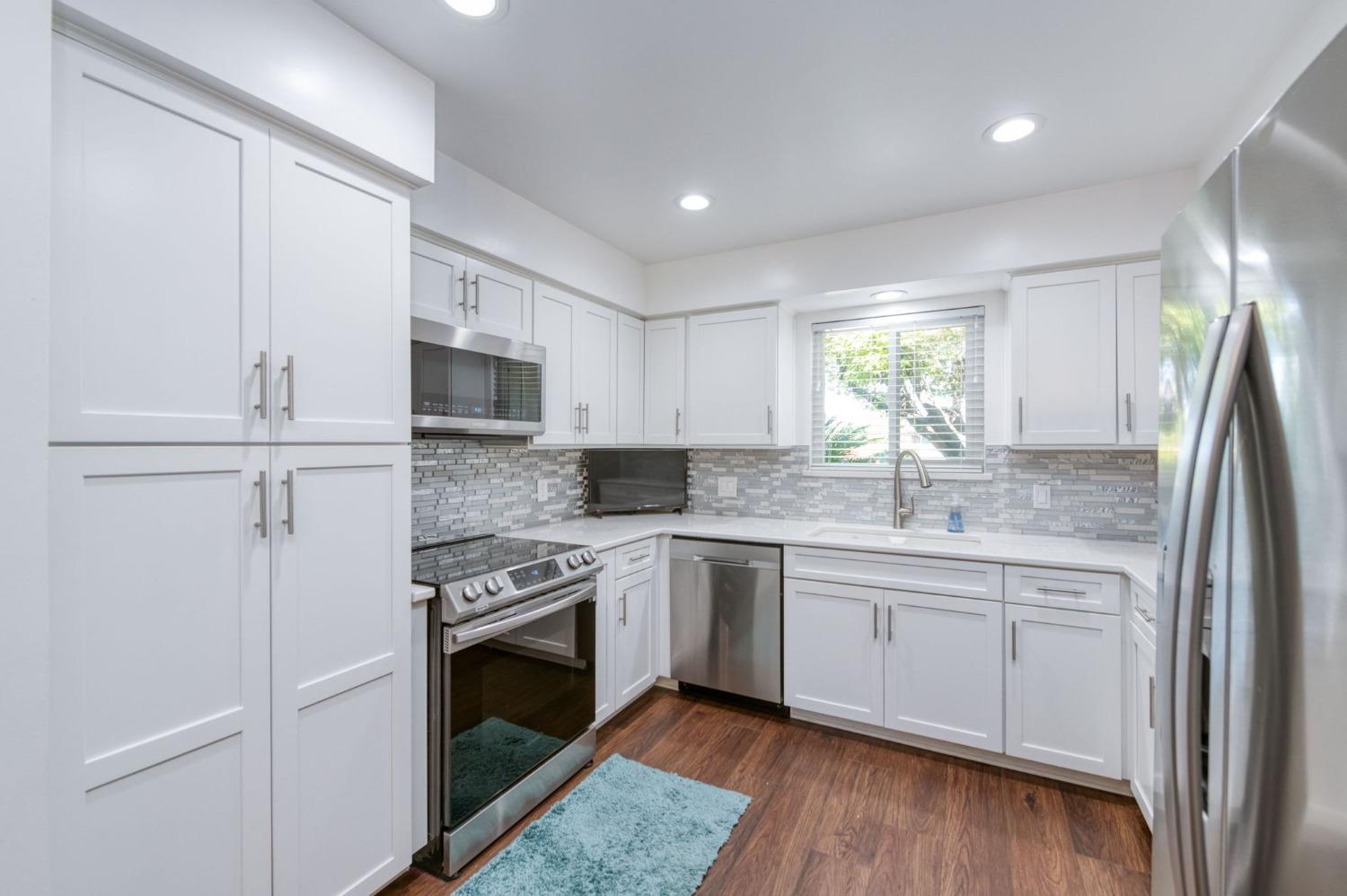 6811 North Backer Avenue Fresno, CA 93710 - Photo 6 of 26 a kitchen with stainless steel appliances granite countertop a stove a sink and a refrigerator