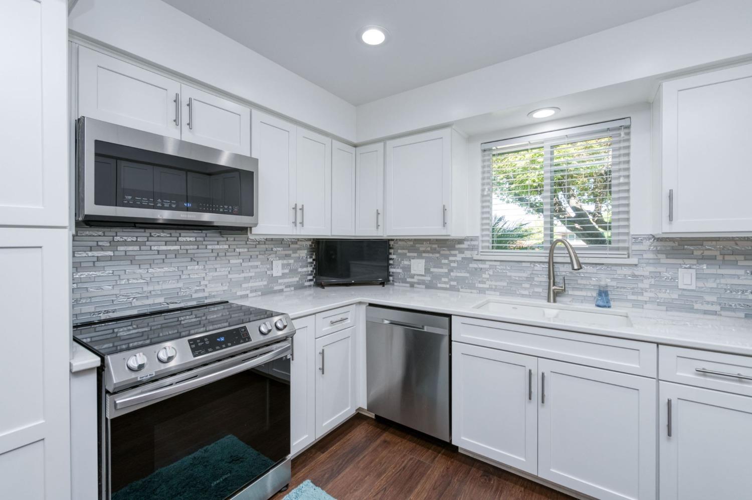 6811 North Backer Avenue Fresno, CA 93710 - Photo 8 of 26 a kitchen with white cabinets appliances and a window
