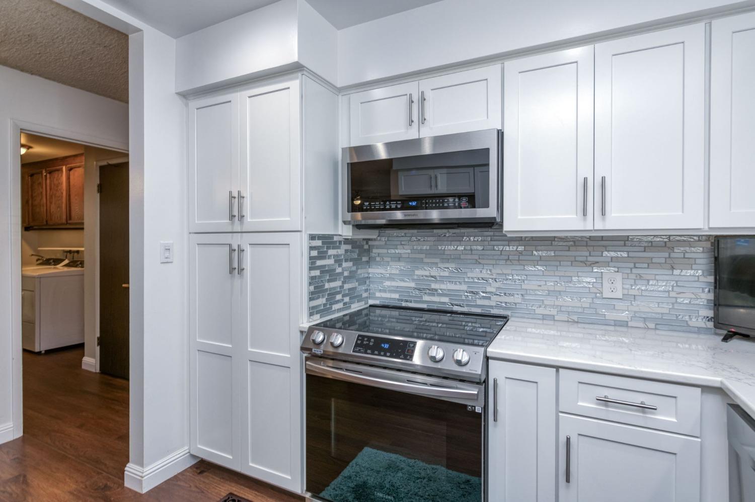 6811 North Backer Avenue Fresno, CA 93710 - Photo 9 of 26 a kitchen with white cabinets and stainless steel appliances