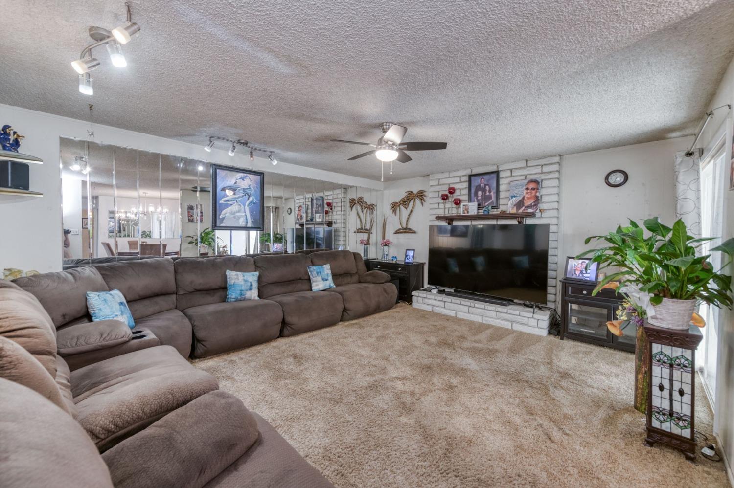 6811 North Backer Avenue Fresno, CA 93710 - Photo 10 of 26 a living room with furniture a fireplace and a potted plant
