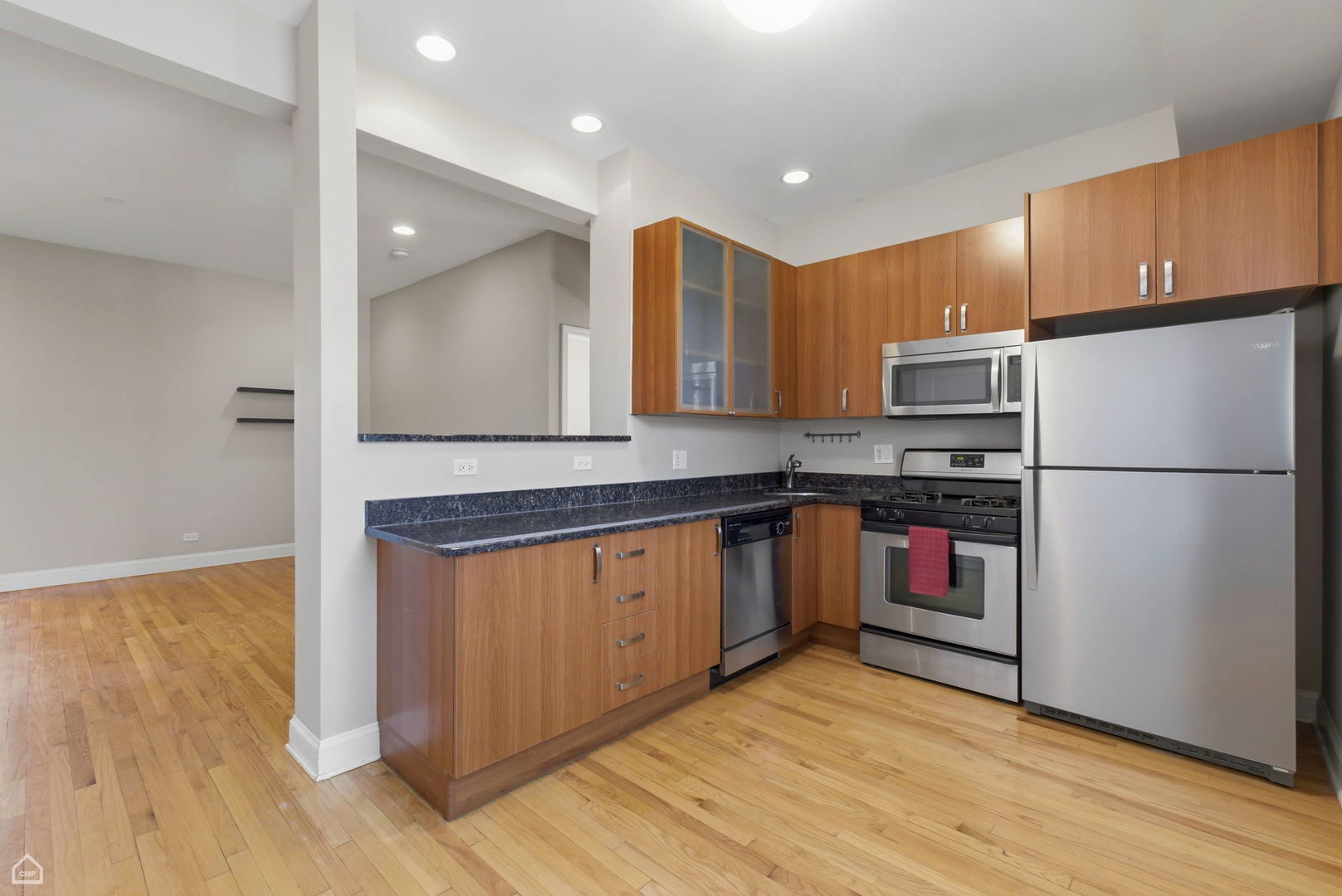 4444 North Beacon Street, Unit 1 Chicago, IL 60640 - Photo 6 of 18 a kitchen with granite countertop a refrigerator and a stove top oven