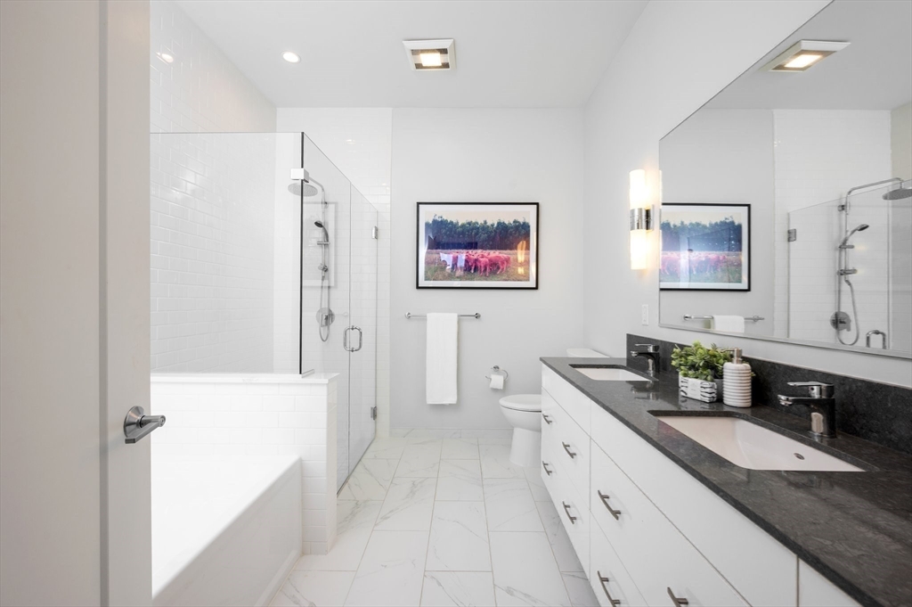 10 Shipyard Drive, Unit 402 Hingham, MA 02043 - Photo 11 of 25 a spacious bathroom with a double vanity sink and a shower