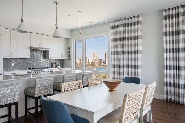 10 Shipyard Drive, Unit 402 Hingham, MA 02043 - Photo 4 of 25 a kitchen with a dining table chairs and white cabinets