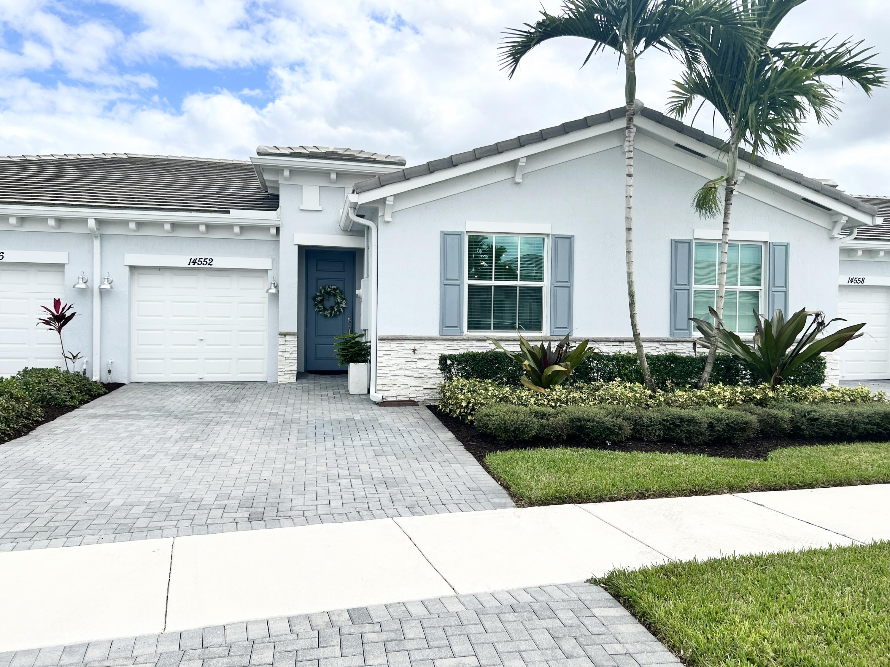 a front view of a house with a yard and a garage