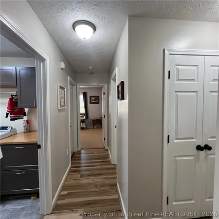 a view of a hallway with wooden floor and staircase