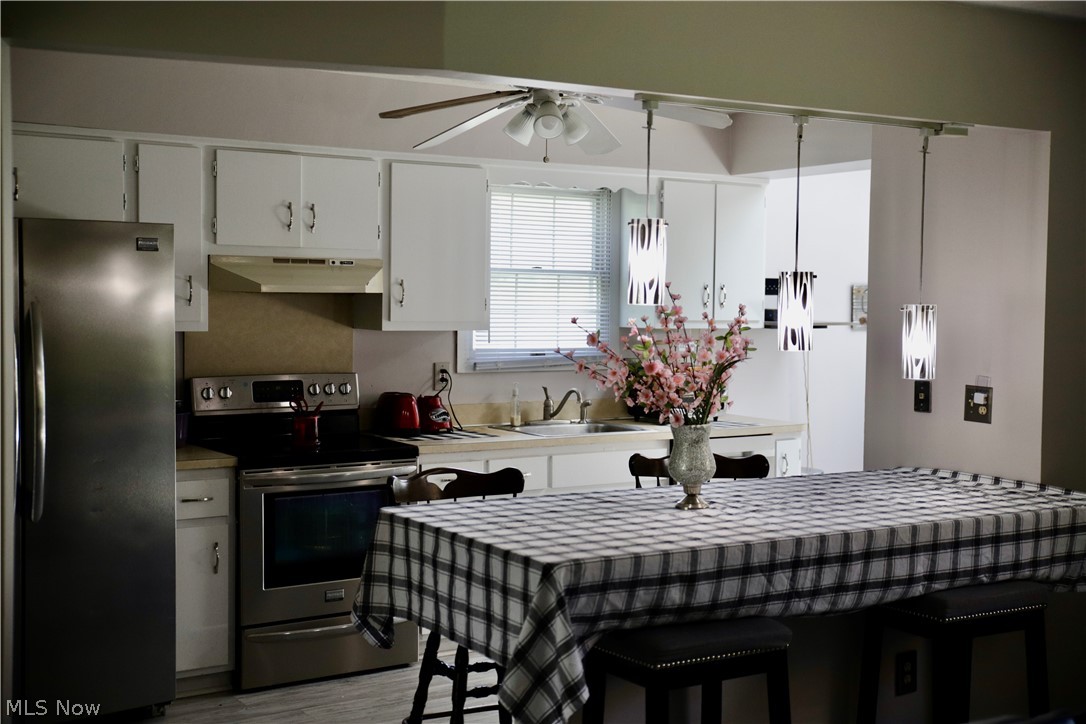 24306 Knickerbocker Road Bay Village, OH 44140 - Photo 7 of 12 Kitchen (appliances stay) and Breakfast Bar with new Pendant lighting.