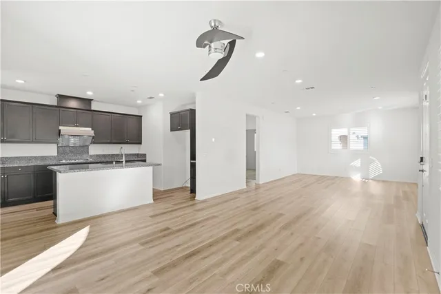 a view of kitchen with granite countertop cabinets and refrigerator