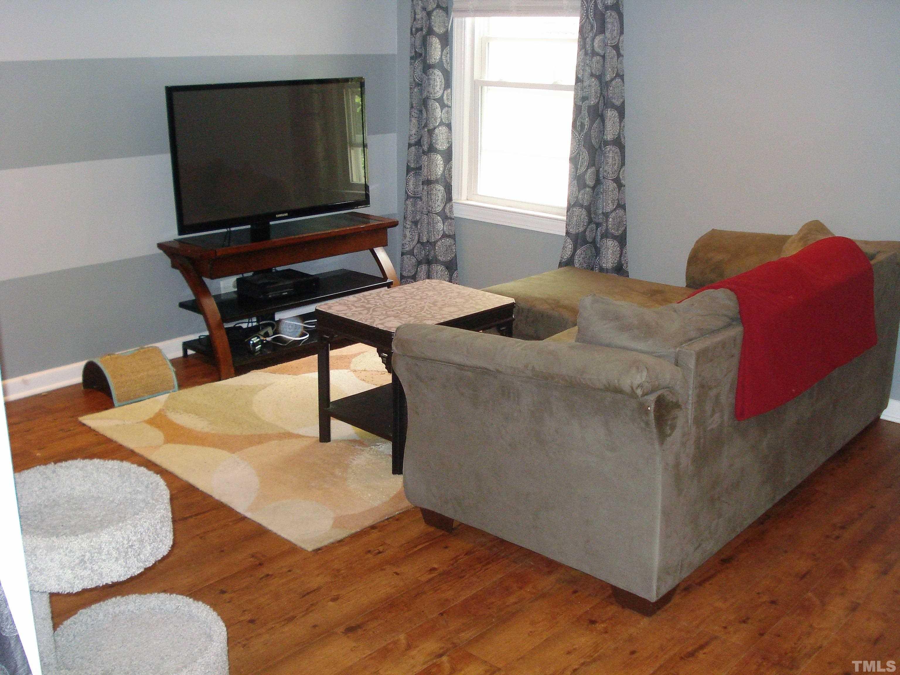 1513 Robinhood Road Durham, NC 27701 - Photo 7 of 13 a bedroom with a bed and a flat screen tv