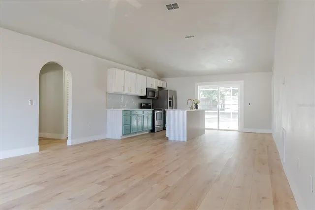 a view of a kitchen with a sink and refrigerator