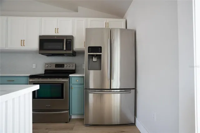 a kitchen with stainless steel appliances a refrigerator stove and microwave