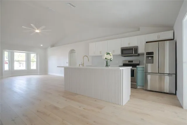 a kitchen with stainless steel appliances a refrigerator sink and microwave