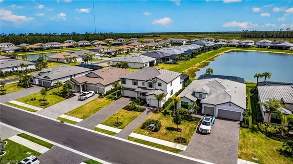an aerial view of residential houses with outdoor space and ocean view