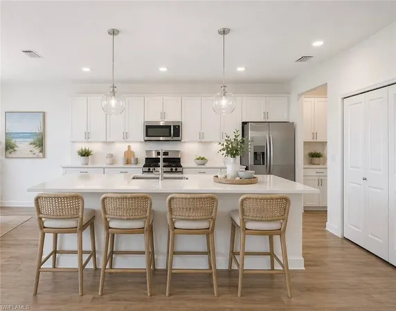 a kitchen with kitchen island granite countertop a table chairs refrigerator and microwave