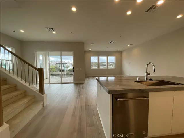 a kitchen with a sink and wooden floor