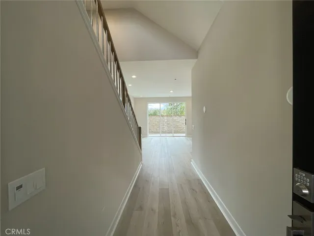 a view of a hallway with wooden floor and staircase