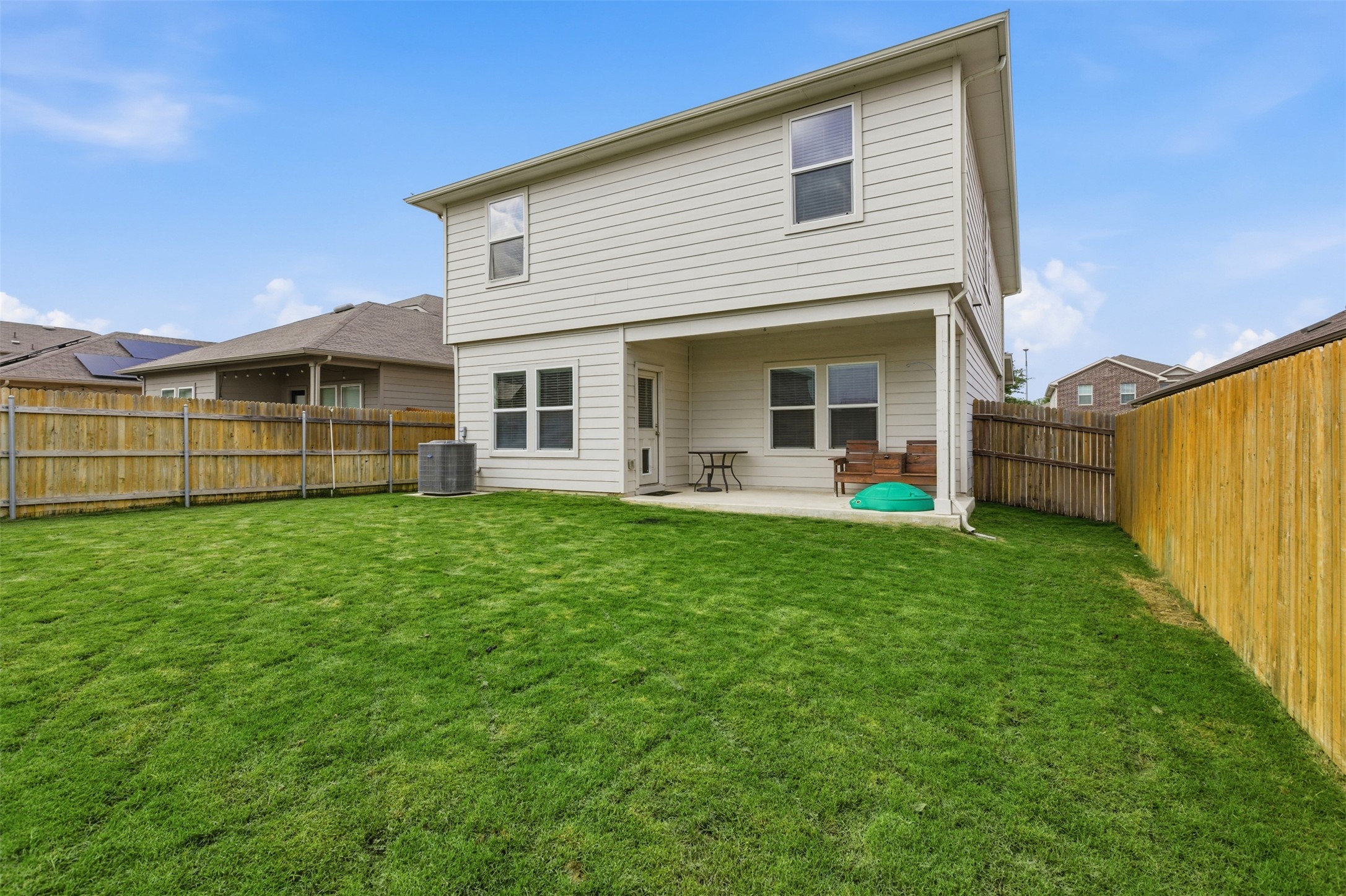 19017 Romano Drive Elgin, TX 78621 - Photo 31 of 33 Expansive backyard featuring a manicured lawn, full privacy fencing, and a covered concrete patio