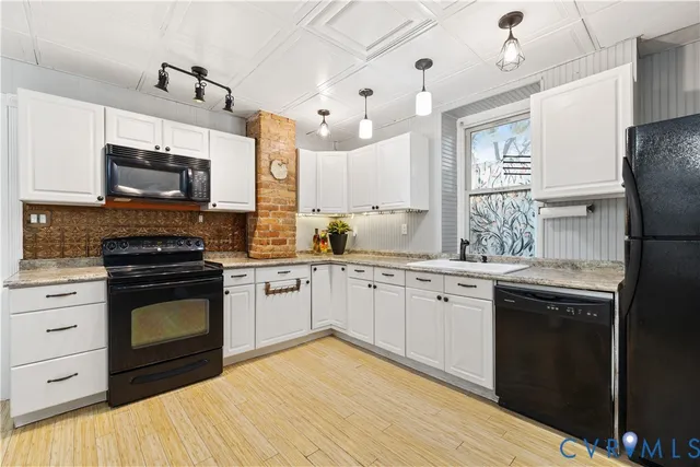 a kitchen with stainless steel appliances granite countertop a stove top oven a sink dishwasher a refrigerator and a microwave