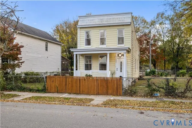 a view of a house with a wooden deck and a yard