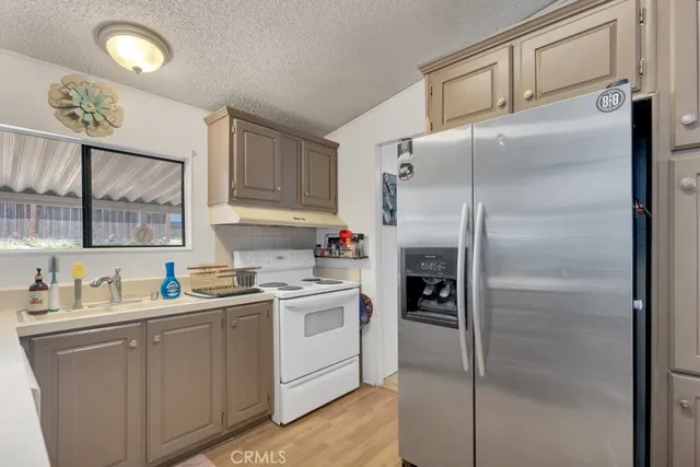 a kitchen with a refrigerator sink and cabinets