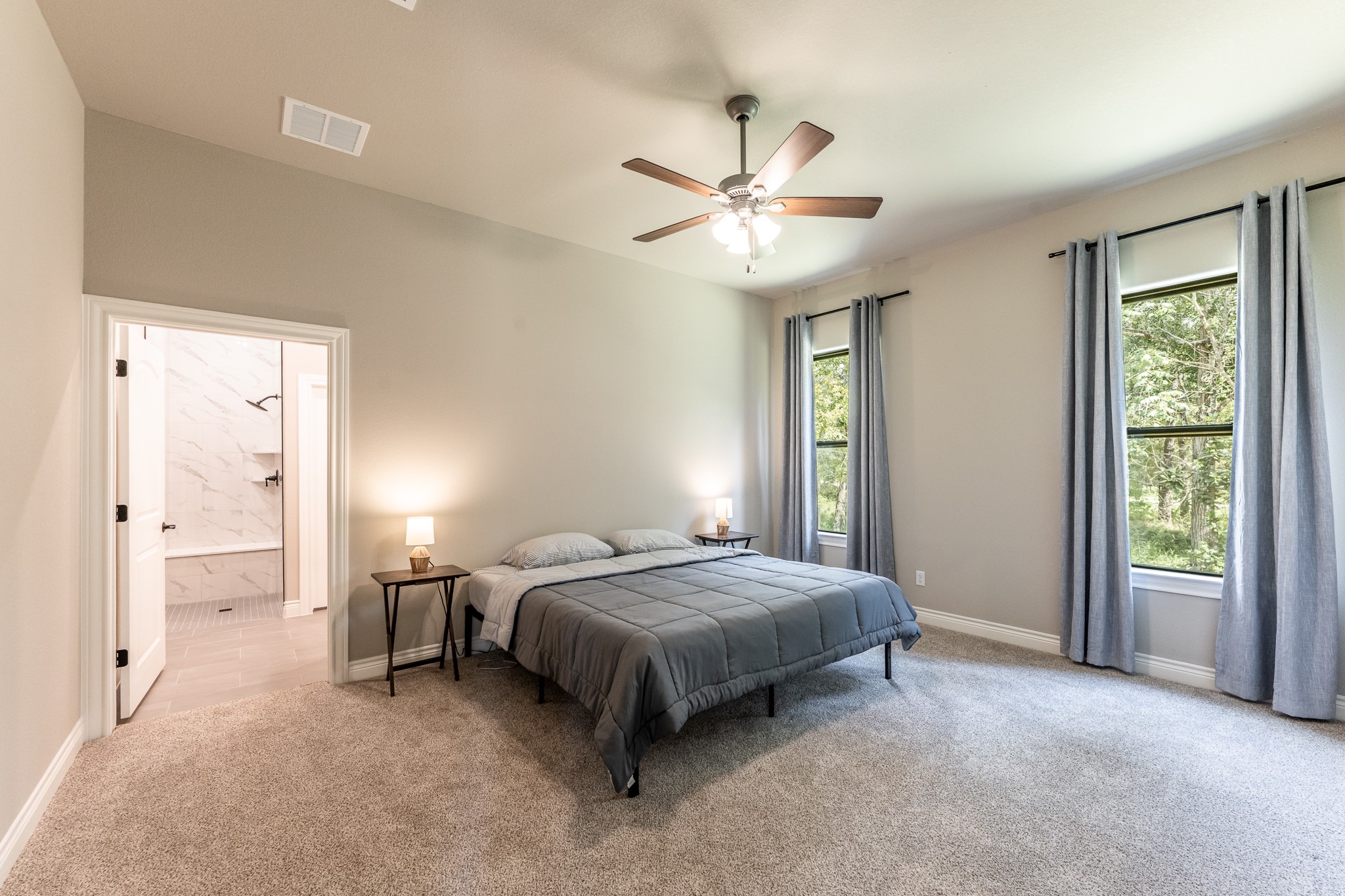 111 Eagle Run Road Willis, TX 77378 - Photo 37 of 44 Spacious primary bedroom featuring large windows for natural light, cozy carpeting, and an en-suite bathroom for ultimate comfort.