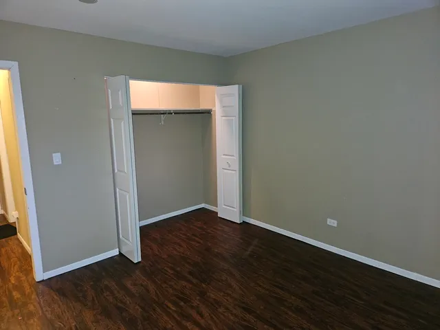 an empty room with wooden floor and closet