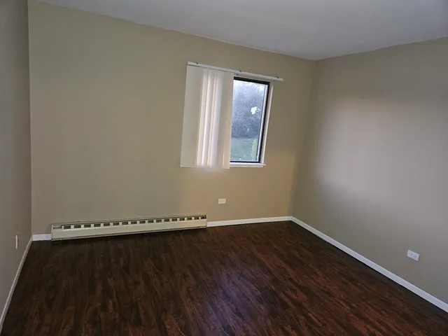 a view of a room with wooden floor and window