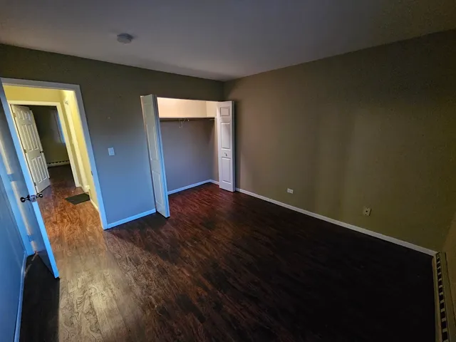 an empty room with wooden floor and mirror