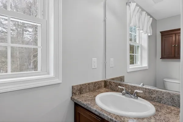 a bathroom with a granite countertop sink and a mirror