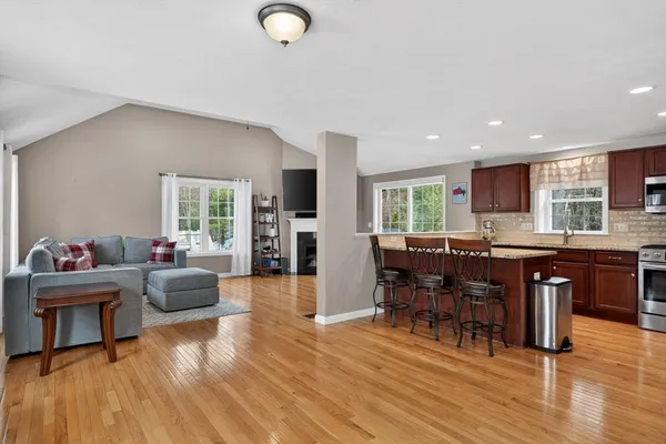 a living room with furniture a dining table and wooden floor
