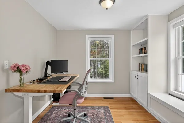 a view of a workspace with furniture and a window
