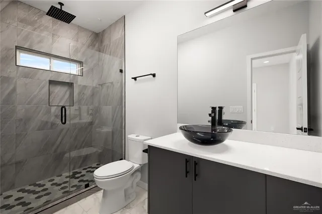 a bathroom with a sink a toilet and shower