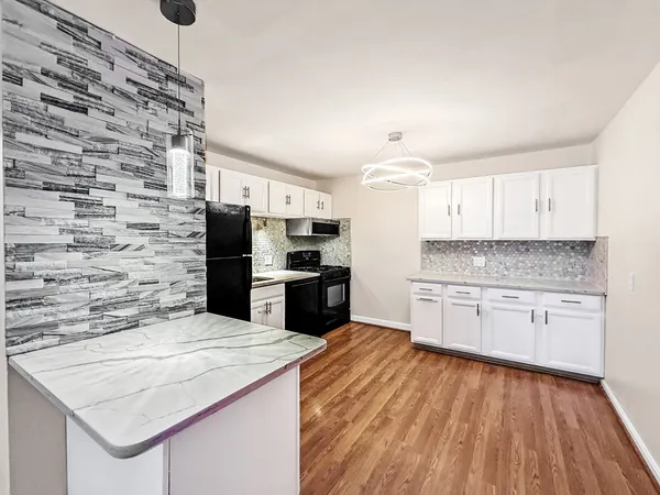 a kitchen with granite countertop a stove top oven a sink dishwasher and a refrigerator with wooden floor