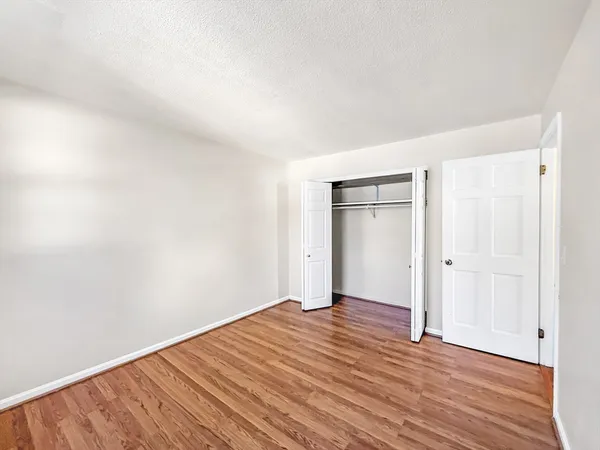 a view of an empty room with wooden floor