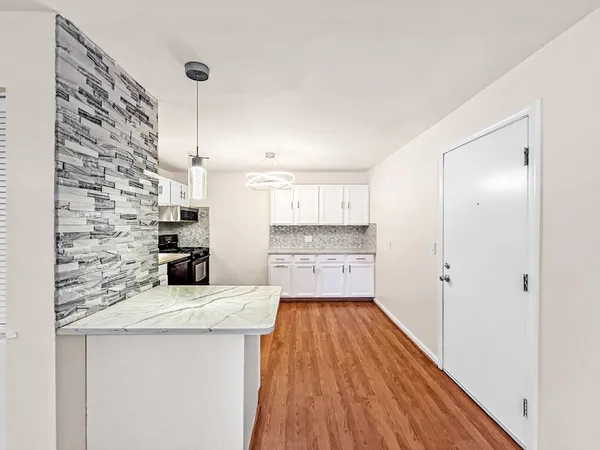 a kitchen with granite countertop a sink and a refrigerator