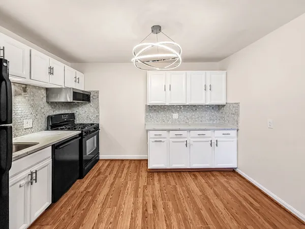 a kitchen with a sink and wooden floor